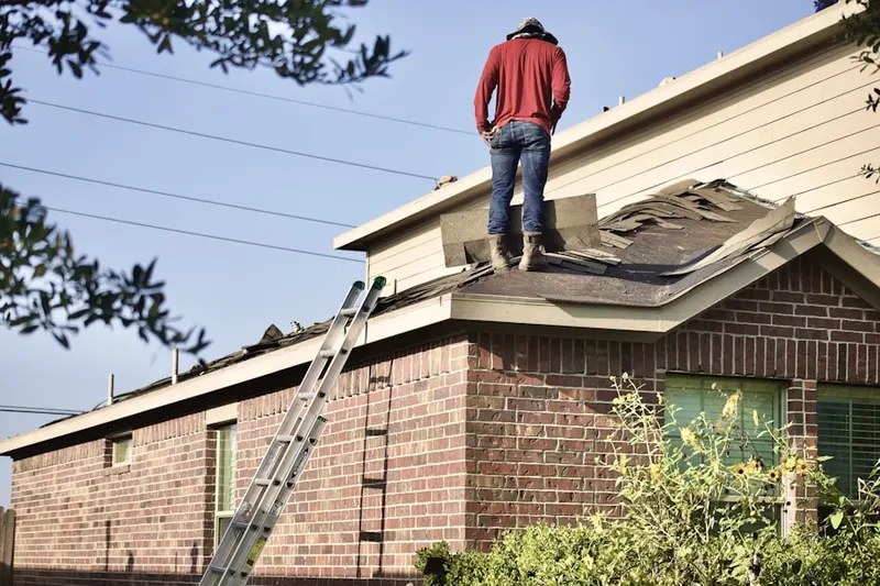 Professional roofer working on a residential roof in Wilna